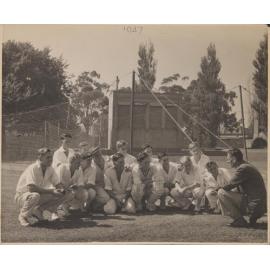Cricket XI 1947 crouching against the nets
